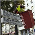 Une personne de l'entreprise JC Decaux nettoie des panneaux de signalisation, le 06 octobre 2006 à Paris.