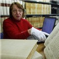 Mme Denis-Gouyette montre un ancien registre d'état civil que des bénévoles vont mettre sur le site internet des archives municipales de Rennes, le 7 février 2007