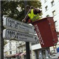 Une personne de l'entreprise JC Decaux nettoie des panneaux de signalisation, le 06 octobre 2006 à Paris.